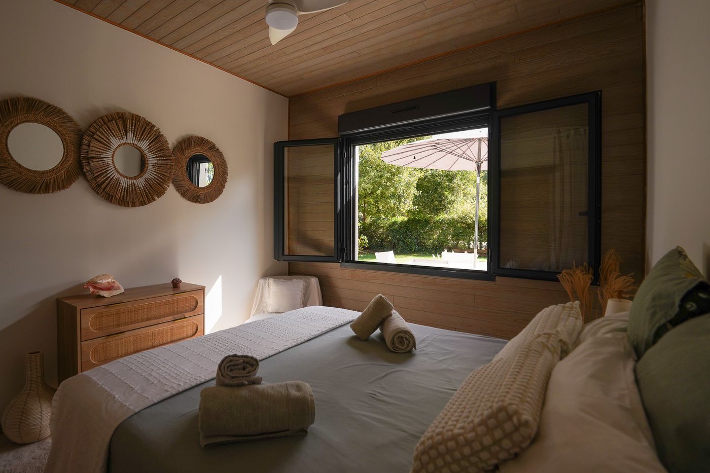 Gästezimmer mit 160-cm-Bett, bereitgelegten Handtüchern und Fenster zum Garten