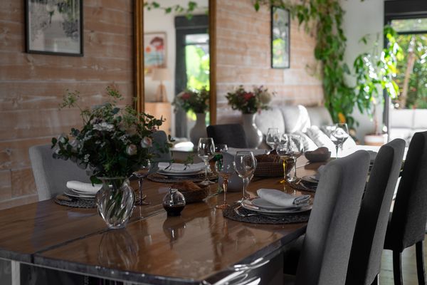 Gedeckter Esstisch mit Gläsern und Blumenstrauß