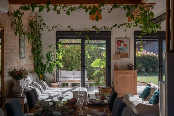 Wohnbereich mit Sofas und Tisch, große Glastüren zum Garten