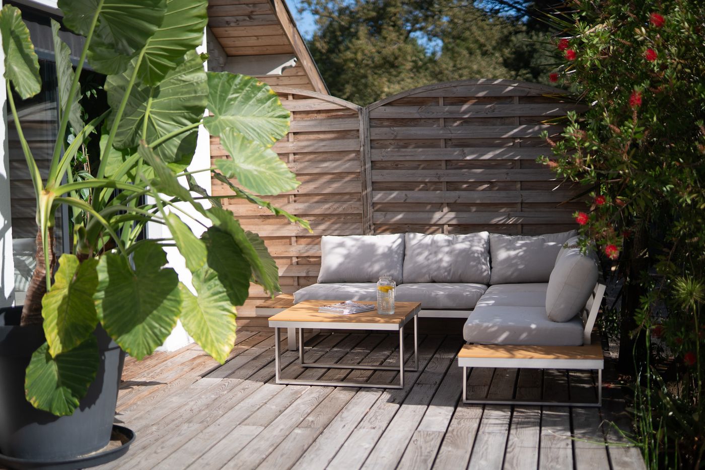 Lounge im Freien mit Ecksofa auf der Holzterrasse, Ostseite
